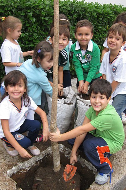 Alunos plantando árvore na frente da Unidade Infantil.